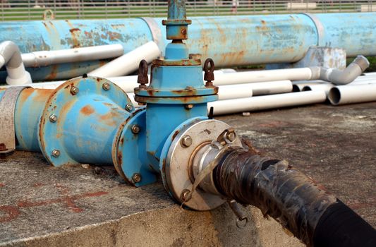 A large fuel hose is connected to a blue pipeline