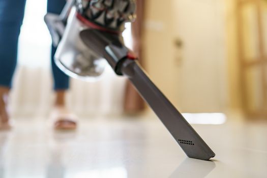 Woman use vacuum cleaner cleaning on floor.