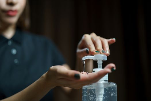 hands using wash hand sanitizer gel pump dispenser. Clear sanitizer in pump bottle, for killing germs, bacteria and virus.