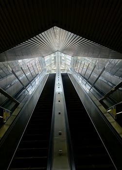 A set of long escalators lead out of a pedestrian underground passage
