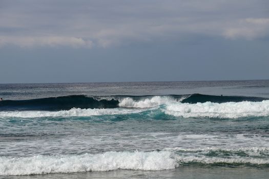 Big breaking wave with glowing green water and big white spray and foam filling the frame. Image taken in Bali. Big large surfing wave during big swell. A Perfect big breaking Ocean barrel wave.