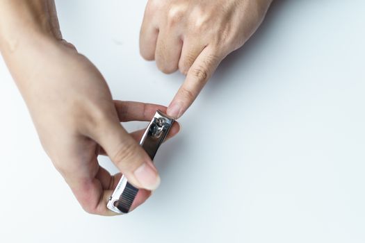 Man using nail clipper clipping her fingernails. white background