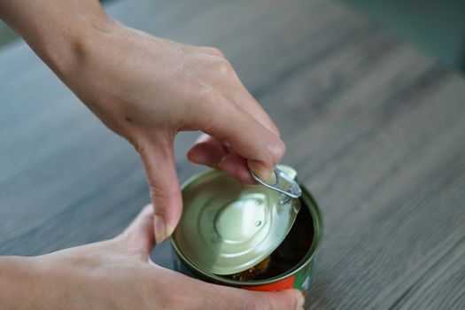 The hand pull and open the tin canned.