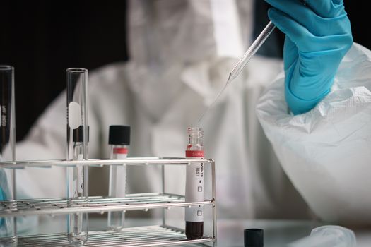 Coronavirus testing process, a hand holds tube drop chemical solution in blood test samples.