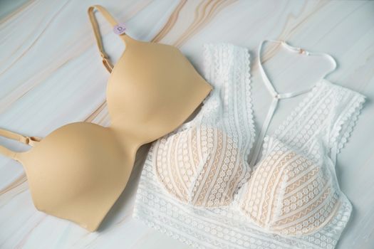 Different color bras on white marble background.