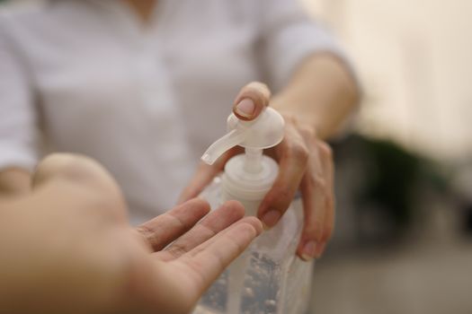 Woman sharing alcohol gel or sanitizer gel for washing hands, corona virus or Covid-19 protection.
