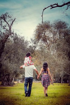 Family walking through the woods with daughter on father's shoulders