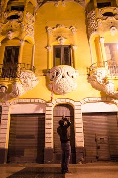 Man taking pictures at night on the streets of downtown Lima - Peru