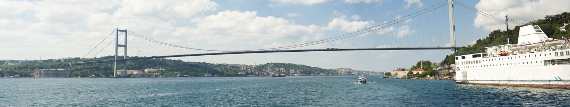 Ataturk suspension bridge spanning the Bosphorus river in Istanbul, Turkey against a blue sky