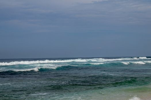 Big breaking wave with glowing green water and big white spray and foam filling the frame. Image taken in Bali. Big large surfing wave during big swell. A Perfect big breaking Ocean barrel wave.