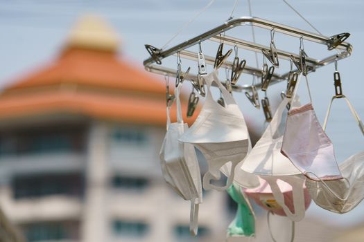 Surgical mask hanging from a drying rack after use and wash. Concept reusing masks.