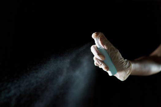 Hand using sanitizer spray, alcohol spraying disinfectant to stop spreading coronavirus or COVID-19.