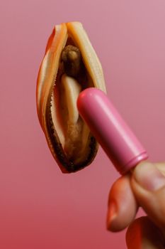 vagina symbol, mussel and pink vibrating sex toy on red background. Concept masturbation