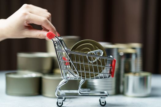 Canned food in shopping cart toy with Hand , group of Aluminium canned food.