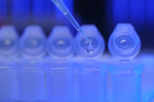 Medical equipment. Pipette adding fluid to one of several test tubes .
