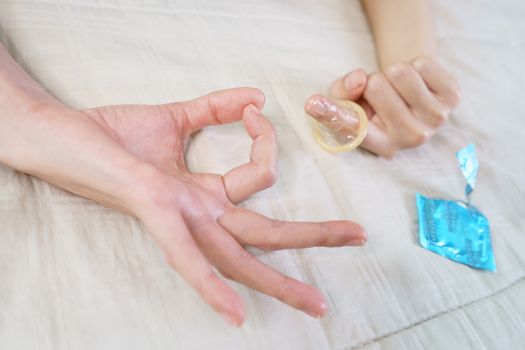 The sex hand sign. women's hands gesture indicating sex and putting condom on her fingers.