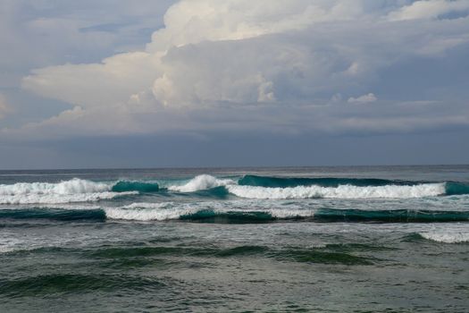 Surfer in the ocean waiting for a wave. Surfers waiting for good surfing waves. Surfers waiting for their wave. Young man waiting for big wave at Nyang Nyang beach, Bali, Indonesia