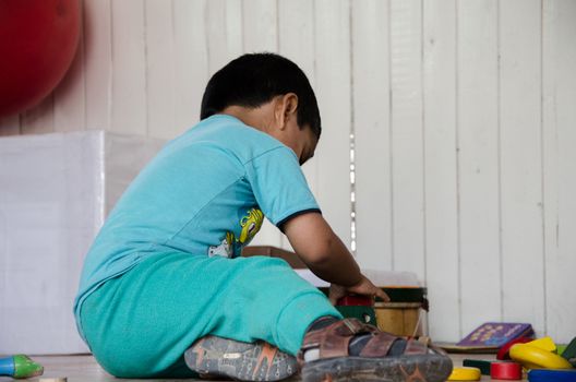 Boy playing and looking for toys in a box