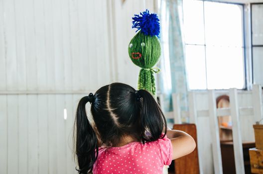 A little girl playing with a toy that has the shape of an octopus