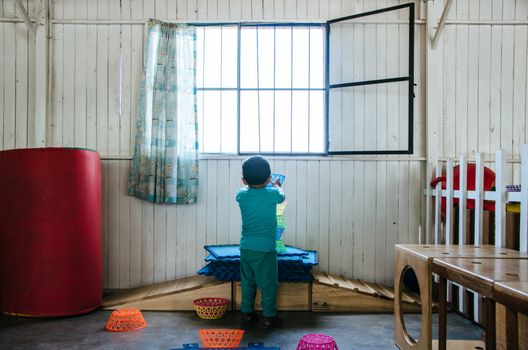 Boy playing to form a tower with plastic baskets