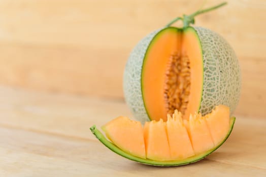 Fresh Orange melon on wood plate