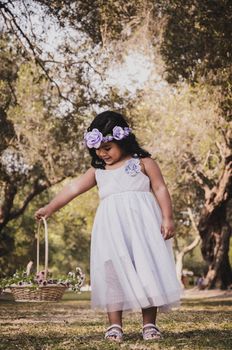 Little girl with a basket of flowers smiling