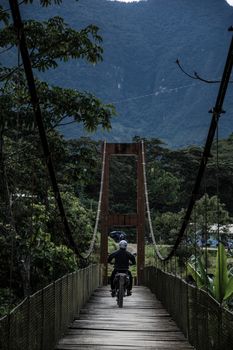 Motorcycle crossing the La Cañera pedestrian bridge located in Oxapampa - Peru