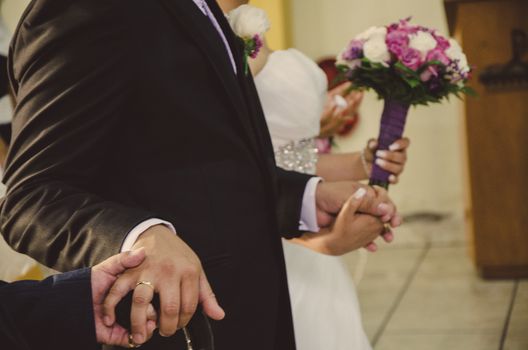 Bride and groom holding hands at the altar