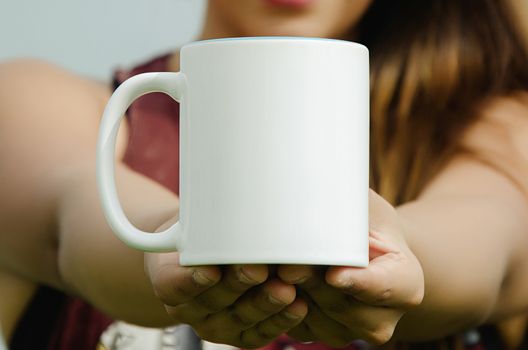 Blank cup in hand of a girl smiling
