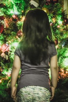 Girl on her back, in front of a Christmas tree