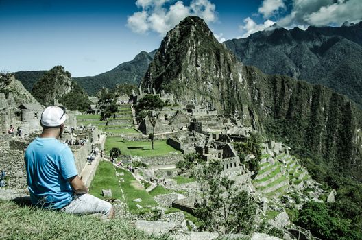 Man sitting in front of the wonder of the world in Machu Picchu located Cusco - Peru