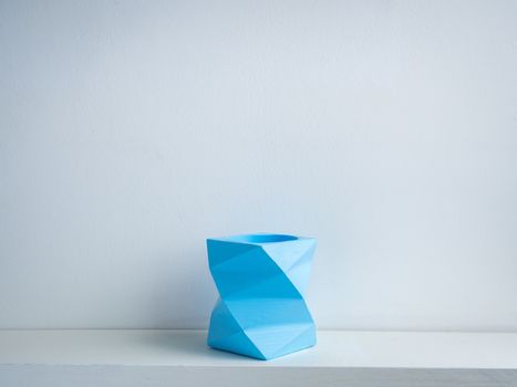 Cactus pot. Concrete pot. Empty blue modern geometric concrete planter on white wooden shelf isolated on white background.