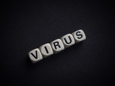 Coronavirus or Covid-19 concept. Wooden cubes text "VIRUS" on dark background.