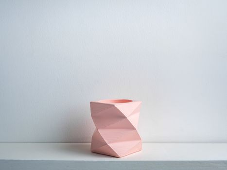 Cactus pot. Concrete pot. Empty pink modern geometric concrete planter on white wooden shelf isolated on white background.