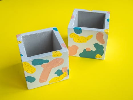 Cactus pot. Concrete pot. Two empty modern geometric concrete planters on yellow background.