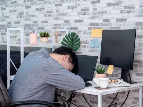 Asian man working hard and sleeping on laptop computer in his room, condominium. Work at home and business online concept.