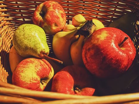 Organic apples, pears and bananas on rustic in a wicker basket, fruits farming and agriculture