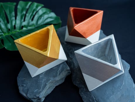 Cactus pot. Concrete pot. Gold, silver and copper painted geometric concrete planters on stone and dark background.