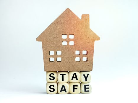 Stay safe concept. Word "Stay Safe" with wooden house isolated on white background, stay at home, social media campaign for covid-19 or coronavirus pandemic prevention.