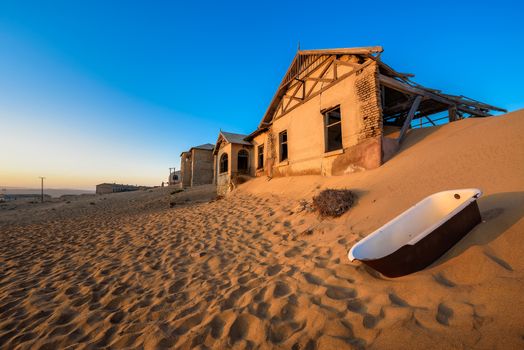 Empty bathtub placed outside in the sand desert around the ghost town of Kolmanskop.