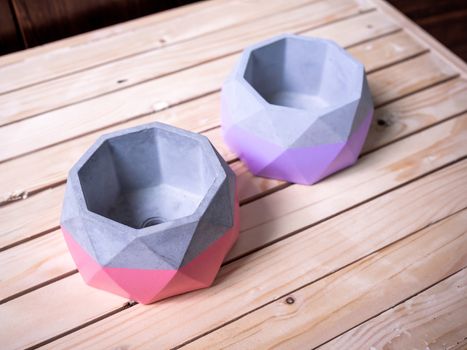 Cactus pot. Concrete pot. Two empty pink and purple modern geometric concrete planters on wooden table, top view.