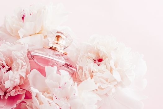 Luxe fragrance bottle as girly perfume product on background of peony flowers, parfum ad and beauty branding design