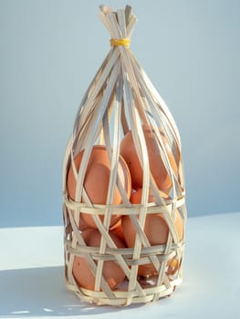 Eggs in bamboo basket isolated on grey background vertical style.