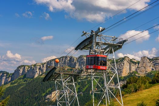 Ebenalp, Switzerland - July 18, 2019 : Red cable railway car transports tourists from Wasserauen to Ebenalp mountain in the Swiss Alps in Appenzell region of Switzerland.