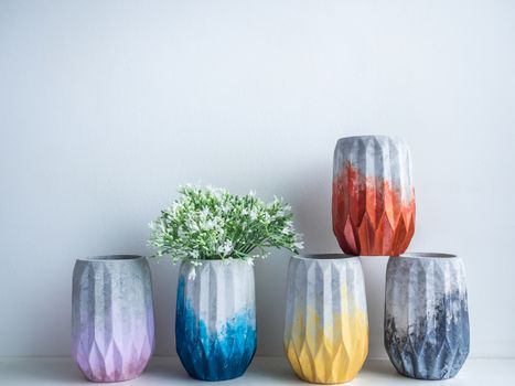 Cactus pot. Concrete pot. Empty colorful concrete planters with flowers on white wooden shelf isolated on white background with copy space.