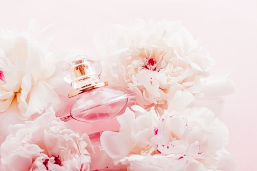 Luxe fragrance bottle as girly perfume product on background of peony flowers, parfum ad and beauty branding design