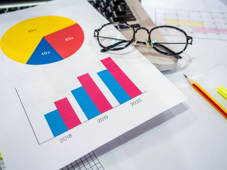 Business goal concept. Business accessory, diagrams graphs, pencil, laptop computer, glasses and highlighter pen on table.