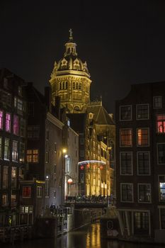 Night view on the basilica Saint Nicolas from the canal and red light district, Netherlands. High quality photo