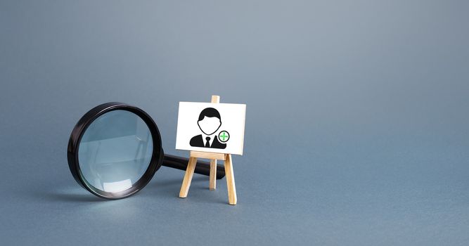 Magnifying glass and an easel with a new hired employee. Recruiting and HR management. Hiring new workers, staffing. Headhunters and Human Resources. Search for skilled specialists and professionals.
