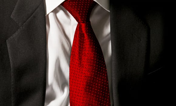 The boss's tie. The businessman is wearing his dark gray jacket on the white shirt with a gaudy red tie